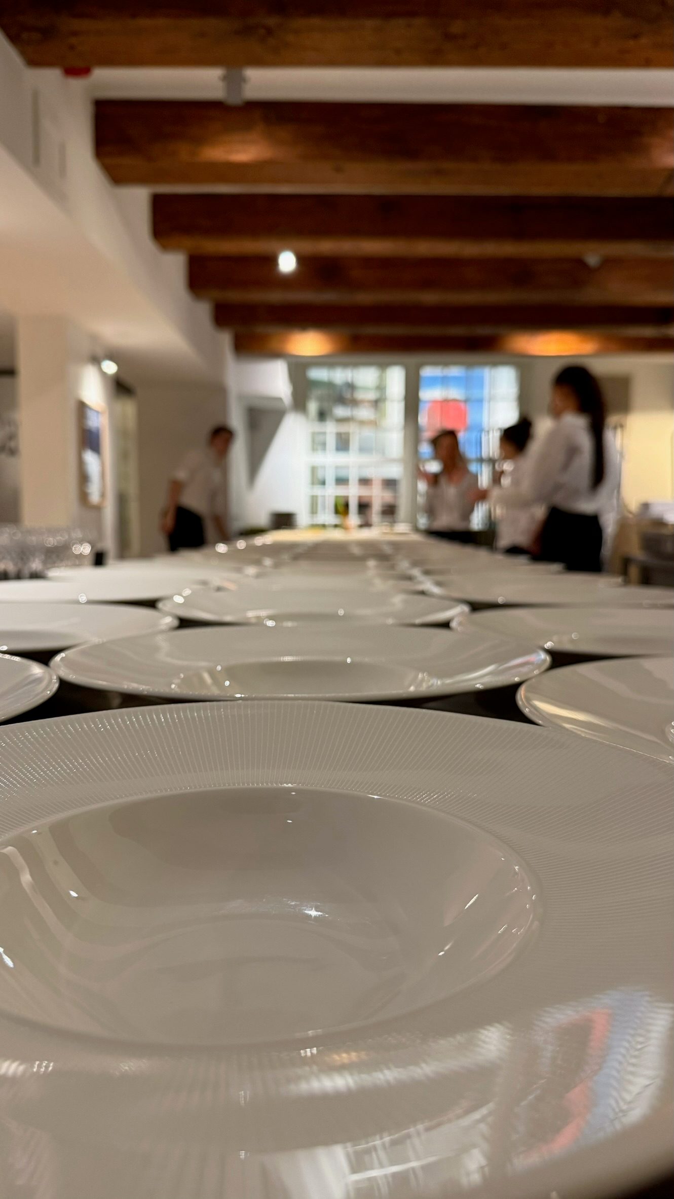 Behind-the-scenes moment of chefs assembling and garnishing plates in the prep area